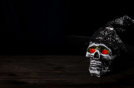 Halloween still-life background with decorative skull on a dark wooden table. copy spaceの写真素材
