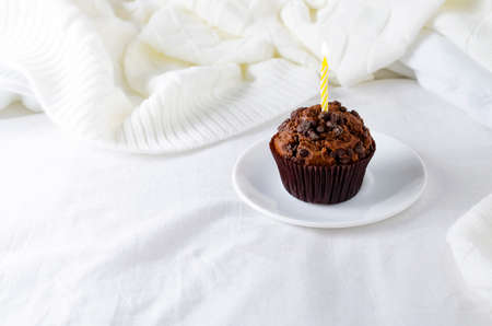 Muffins or capkakes with chocolate on a plate in bed. White background. Sweet food. Festive mood copy spaceの写真素材