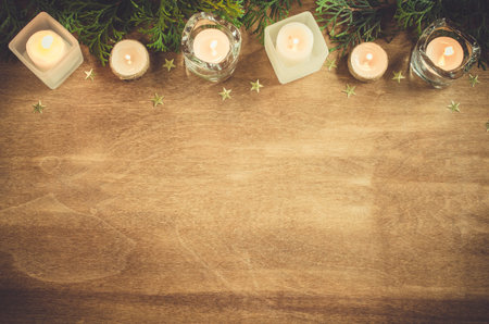 Christmas background with fir tree, burning candles and decoration on wooden board. Advent time. Toned image Copy Spaceの写真素材