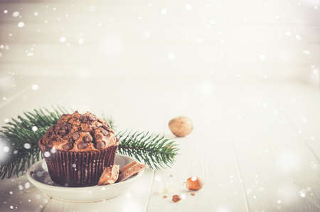 Chocolate muffin on white wooden background. Snow effect. Selective Focus Copy space. Vintage stile. Toned imageの写真素材