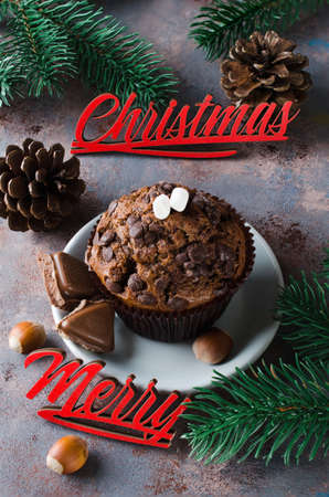 Chocolate muffin, branches fir and Merry Christmas inscription. Xmas time. Selective Focus. Copy space.の写真素材