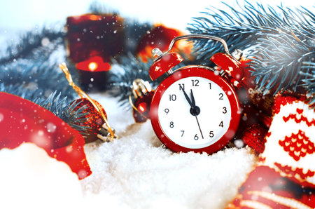Christmas Eve and New Years clock at midnight with frosty fir tree branches covered with snow.