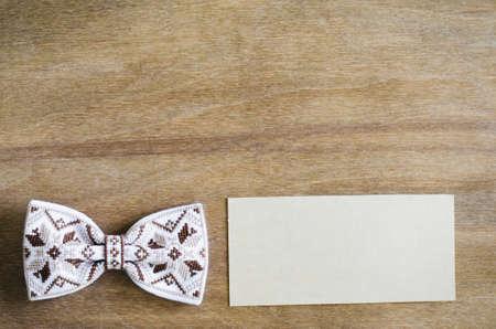 Embroidered Bow Tie and Empty Card on Wooden Brown Background. Father's day Concept. Rustic Styleの写真素材