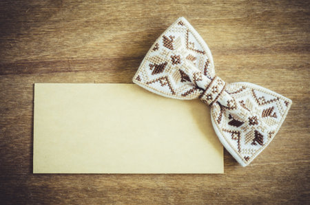 Embroidered Bow Tie and Empty Card on Wooden Brown Background. Father's day Concept. Rustic Styleの写真素材