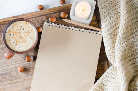 Business, holiday or new year planning concept : Desk table with plaid, empty notebook, candle and coffee cup, Top view or flat lay with copy space ready for adding or mock upの写真素材