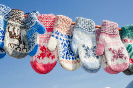Mittens At Winter Christmas Market. A variety colorful knitted of woolen mittens hanging on a rope. Christmas gift or souvenir.の写真素材