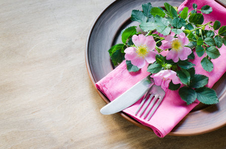 Festive Table setting with delicate pink flowers. Holiday Table Set for Mother's Day or Birthday. Selective Focus.の写真素材