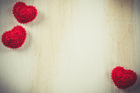 Greeting card for St. Valentine's Day with knitted red hearts on vintage white wooden background. Flat lay copy spaceの写真素材