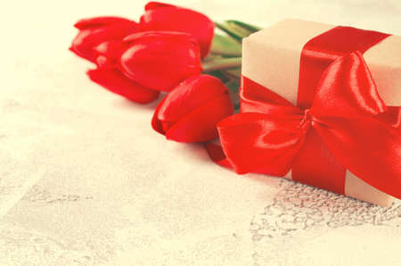 Bouquet of red tulips and gift box on white background. Spring flowers. Spring background. Greeting card for Valentine's Day, Woman's Day and Mother's Day. copy space.の写真素材