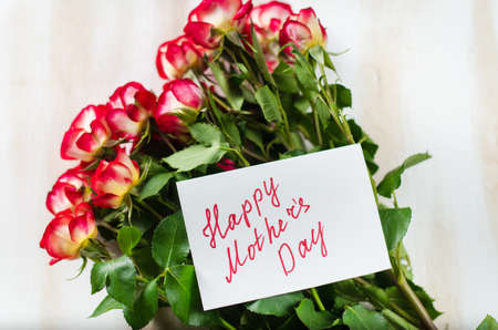 Bouquet of red roses and greeting card with text Happy Mothers Day.の写真素材