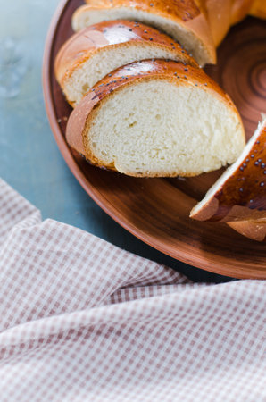Traditional wicker homemade bread. Wheat sliced bun on a wooden background. Rustic sweet bread . Top...