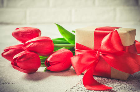 Bouquet of red tulips and gift box on white background. Spring flowers. Spring background. Greeting card for Valentine's Day, Woman's Day and Mother's Day. copy space.の写真素材