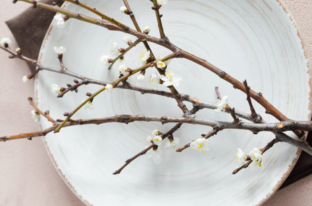 Spring table setting in beige color with flowering branches. Concept Spring, Easter or Mother's Day....