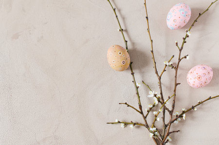 Easter background in beige color with spring flowering branches and easter eggs. Top view, copy space.の写真素材