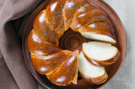 Traditional wicker homemade bread. Sweet wheat sliced bun on a wooden background. Rustic style. Top...