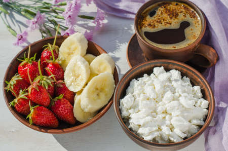 Healthy breakfast. Dieting cottage cheese with fresh fruit, strawberry, banana and coffee.の写真素材