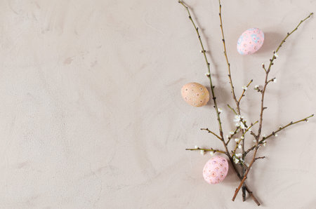 Easter background in beige color with spring flowering branches and easter eggs. Top view, copy space.の写真素材