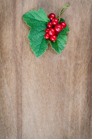 Fresh ripe organic red currant on wooden background. Selective focus, rustic style.