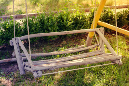 Wooden swing hand-made in the garden. Cozy patio for rest.の写真素材