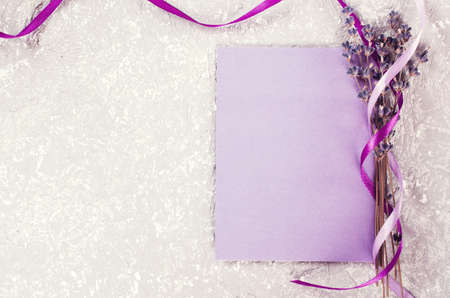 Mock up of holiday background. Bunch of lavender flowers and a purple blank greeting card. Copy space for text. Top view. Vintage toning.の写真素材