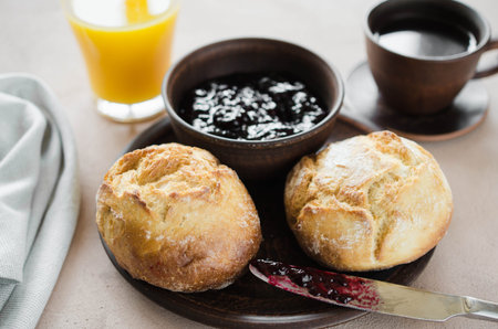 Coffee americano, fresh buns with jam and juice.. Simple breakfast in morning. Rustic style.
