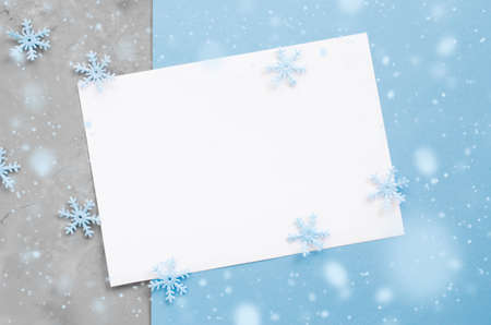 Minimalistic Christmas card mockup with decorative snowflakes in blue color. Empty postcard. Xmas background with snow effect. Top view with copy space.の写真素材