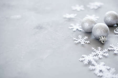 Silver Christmas background. Curly ribbon with decorative balls and snowflakes. Xmas decorations. Place for text.の写真素材