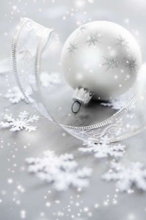 Silver Christmas background. Curly ribbon with decorative balls and snowflakes. Xmas decorations. Copy space, snow effect.の写真素材