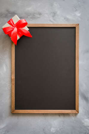 Empty blackboard with red gift box. Background with copy space. Chalk board and one present.の写真素材