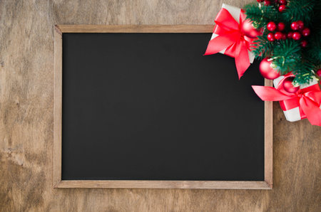 Empty blackboard with christmas decoration, red gift box, fir branches. Chalk board and Christmas...