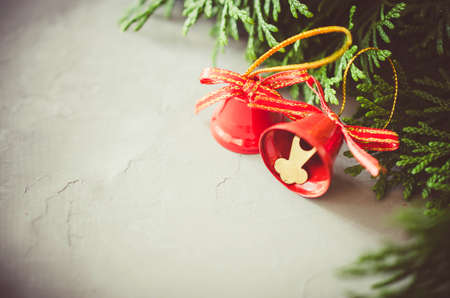 Christmas background with xmas fir branches and red bells. Christmas banner. Toned image.の写真素材