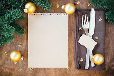 Christmas table place setting for dinner with notebookの写真素材