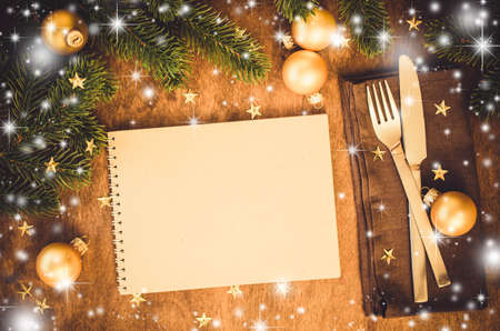Christmas table place setting for dinner with notebookの写真素材