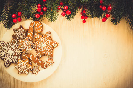 Christmas homemade gingerbread cookies and fir branches on white wooden background. Flat lay. Copy...