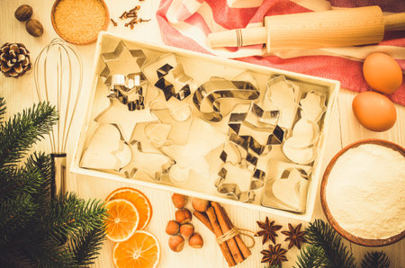 Holiday food background. Christmas cookie cutters, rolling pin and ingredients for baking on white...
