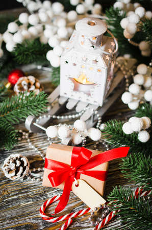 Christmas still life with lantern, gift box and xmas decorations on wooden background.の写真素材