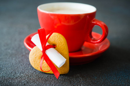 Romantic composition for Valentines Day, Birthday or Mothers Day. Red coffee cup and cookie in the...