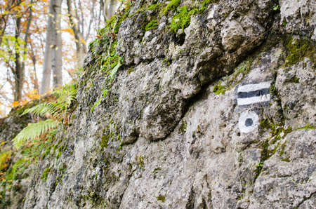 Marking the tourist route painted on the stone. Travel route sign. Season of the autumn.の写真素材