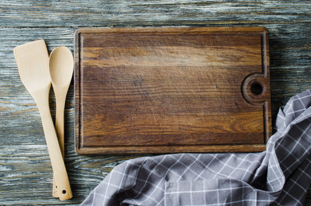 Culinary background with rustic kitchenware: wooden or bamboo cutlery, vintage cutting board and...