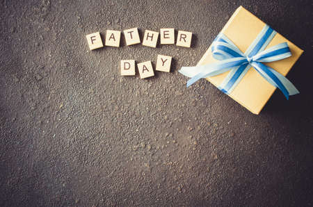 Happy Father's day greeting card with decorated gift box on dark background. Top view.の写真素材