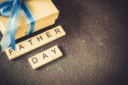 Happy Father's day greeting card with decorated gift box on dark background. Top view.の写真素材