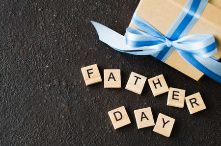 Happy Father's day greeting card with decorated gift box on dark background. Top view.の写真素材