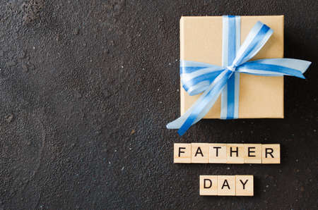 Happy Father's day greeting card with decorated gift box on dark background. Top view.の写真素材