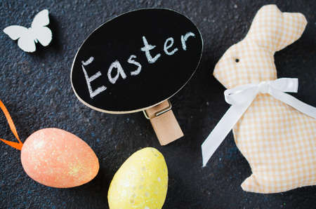 Easter background with decorative rabbit, butterflies and inscription Easter. Holidays background with Easter decorations and copy space.の写真素材