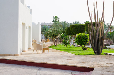 Hotel with well-groomed territory. Beautiful lawn with green grass and beautiful flowers of landscape design at five star hotel territori. Summer in Sharm El Sheikh, Egypt.のeditorial素材