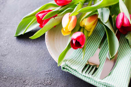 Festive Table Setting With Tulips. Holiday Table Set for Birthday, Mother's Day or for another holiday. Selective Focus.の写真素材