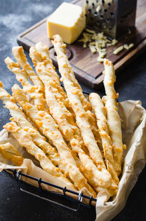 Cheese stick. Breadsticks with cheese on dark background, concept for snack or party timeの写真素材