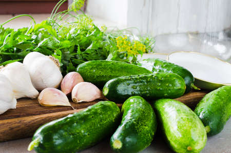 Conservation of fresh green cucumbers for the winter. Preparation marinated salted cucumbers with herbs and spice. Cucumbers with garlic, salt, dill. Pickles in jar, homemade preserved vegetables.の写真素材