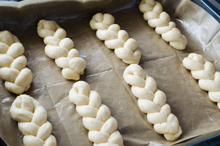 Preparation process - raw unbaked buns. Ready to bake homemade traditional pigtail buns on baking...