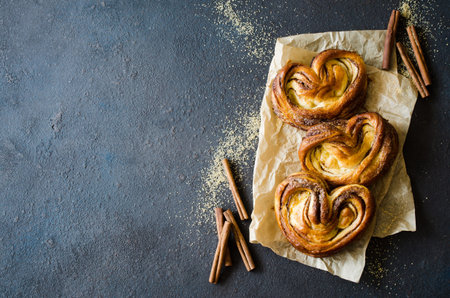 Baked fresh fragrant cinnamon buns. Traditional homemade pastries on dark background. Rustic style.の写真素材